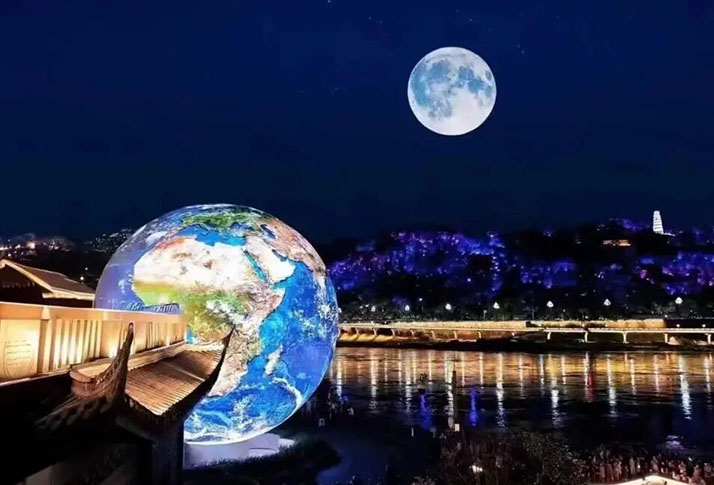 11‑meter outdoor spherical LED landmark displaying earth graphic at riverside public plaza